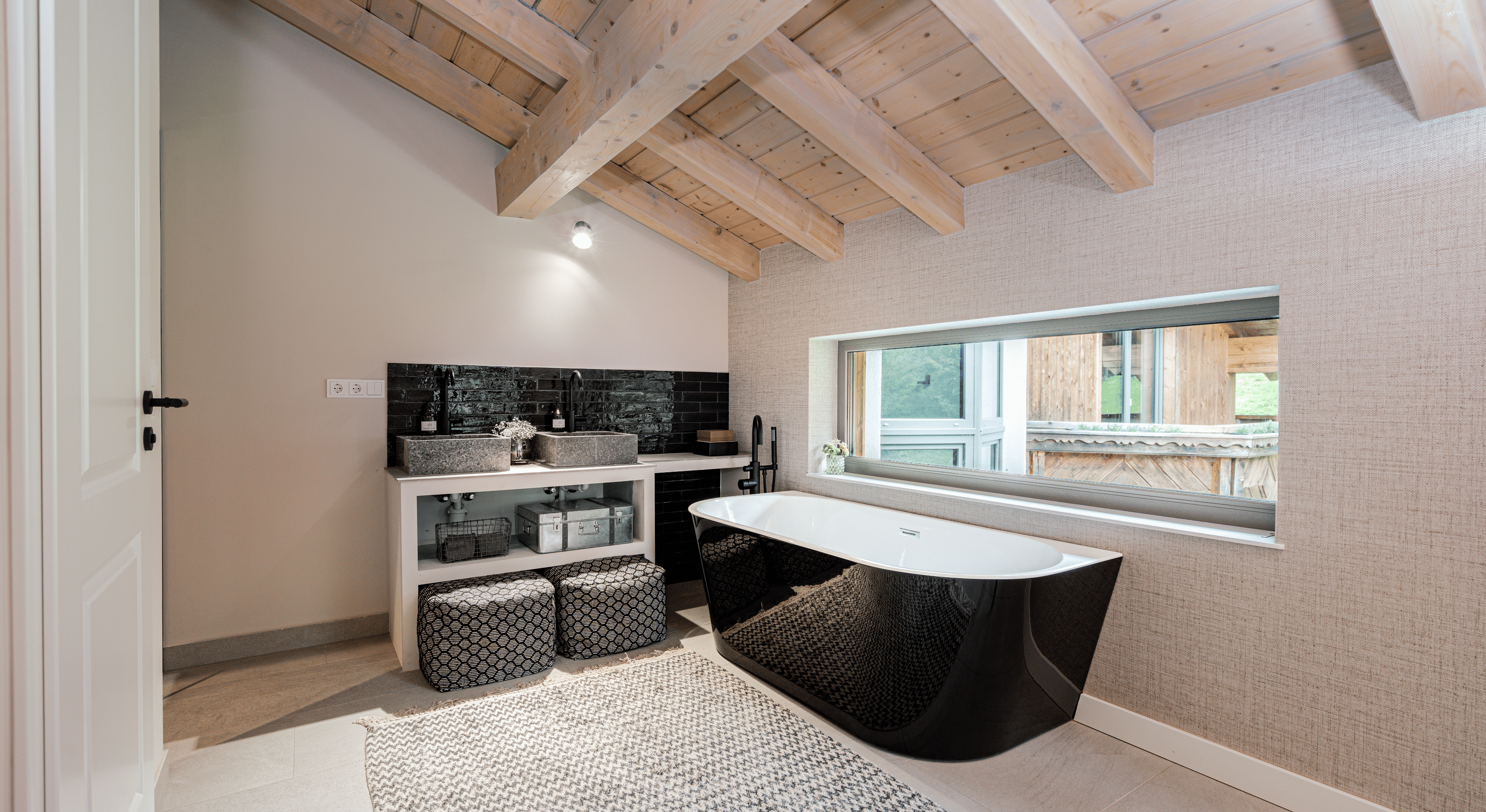 Schlafbereich mit Holzwand und großem Fenster im alpinen Chalet